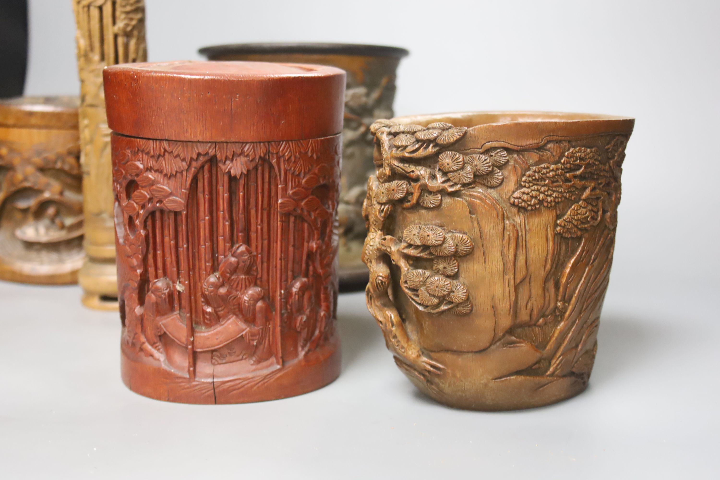 Three Chinese carved bamboo brushpots, largest 16cm diameter 17cm high, together with a carved bamboo scroll box and a carved hardwood plate stand (6)